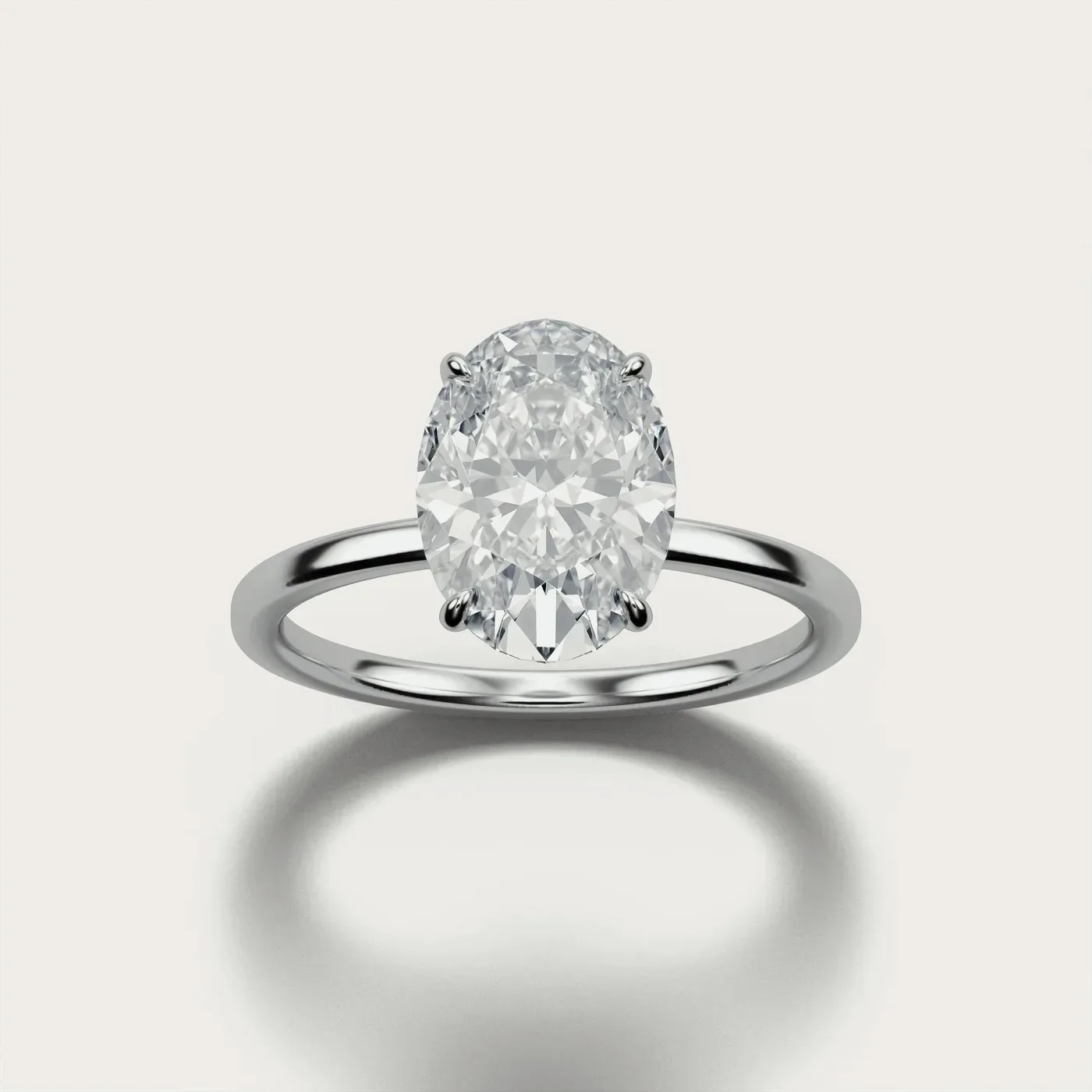 A plain oval solitaire in white gold, lit and photographed identically to the other two