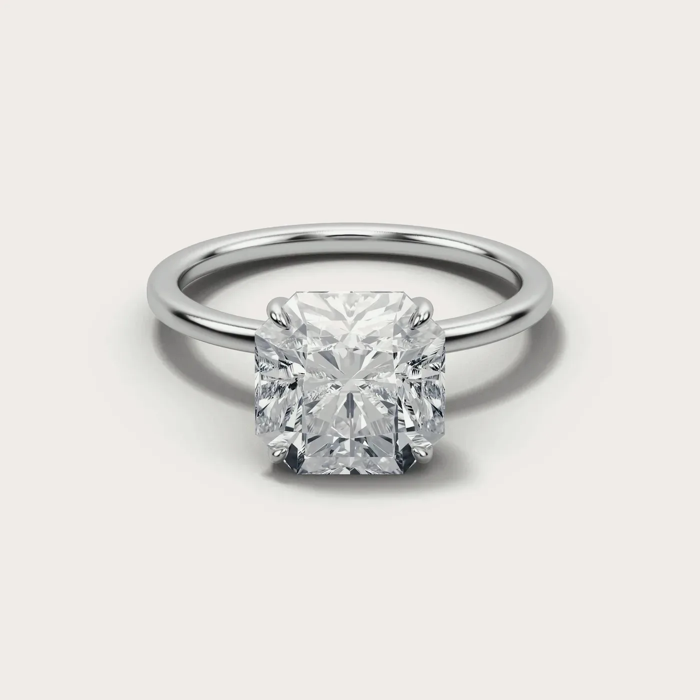 A radiant square cut diamond in the same white gold solitaire, seen from directly above