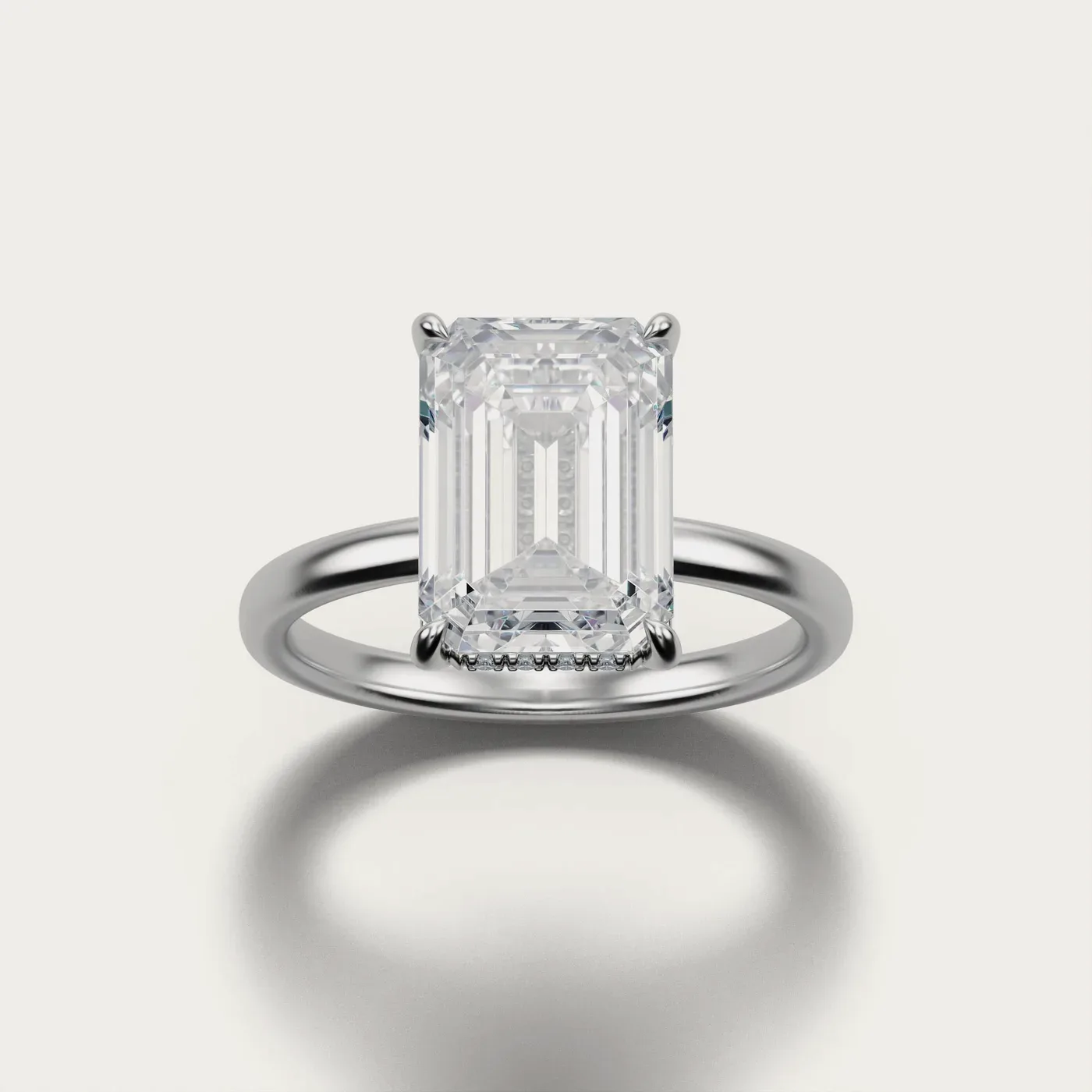 An emerald cut with a hidden halo in white gold, lit and photographed identically to the other two