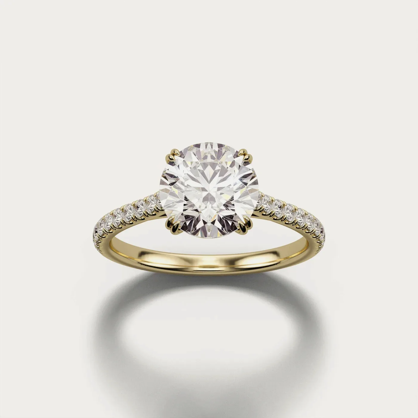 A pavé solitaire in yellow gold, lit and photographed identically to the other two